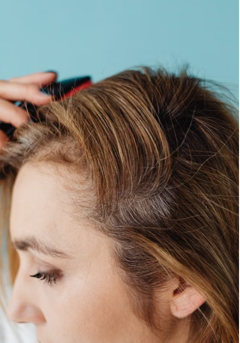 Close-up of hair roots being sectioned with a comb